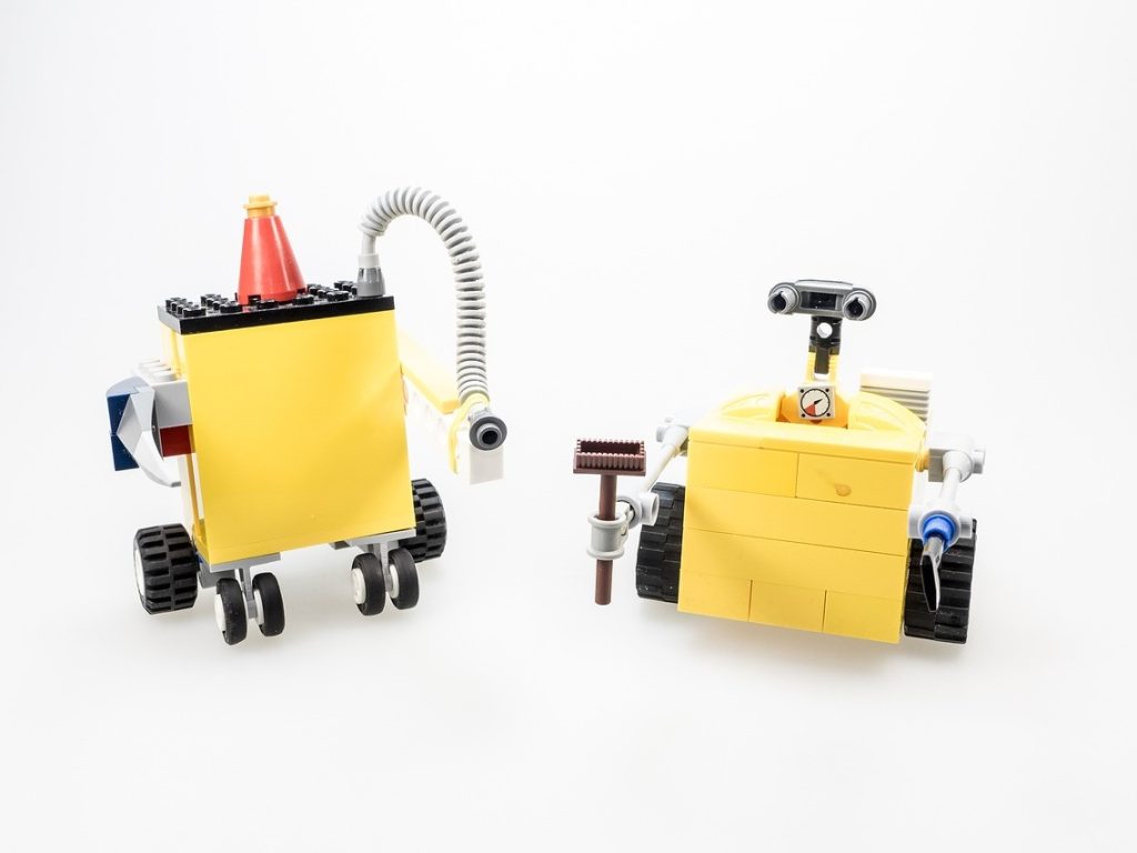 Zwei gelbe Legoroboter stehen nebeneinander.